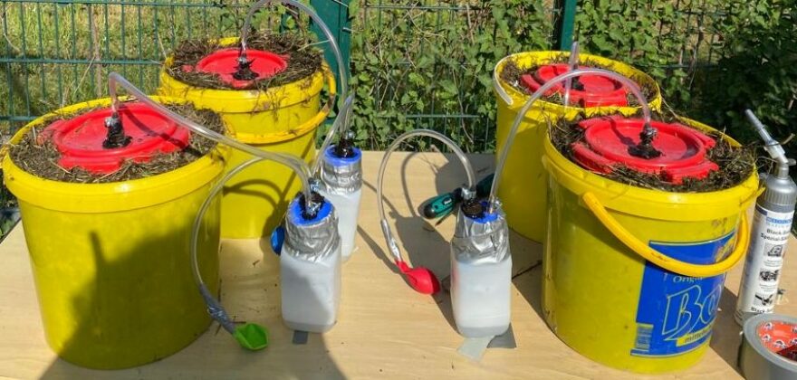 Eimer, Flaschen und Schläuche bilden das Material der Mini-Biogasanlage
